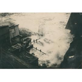 Water pouring from needle valves on the hydroelectric side of dam wall.